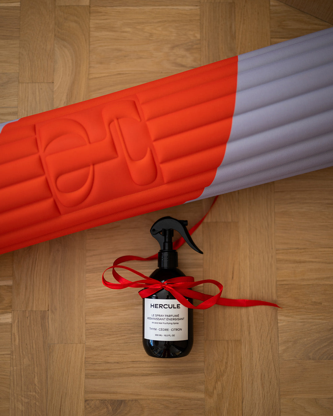 Tapis de sol pour le sport de la marque hercule studio modèle archy imprimé axel rouge orangé et lavande et spray parfumé énergisant pour tapis de sport photo lifestyle de noël