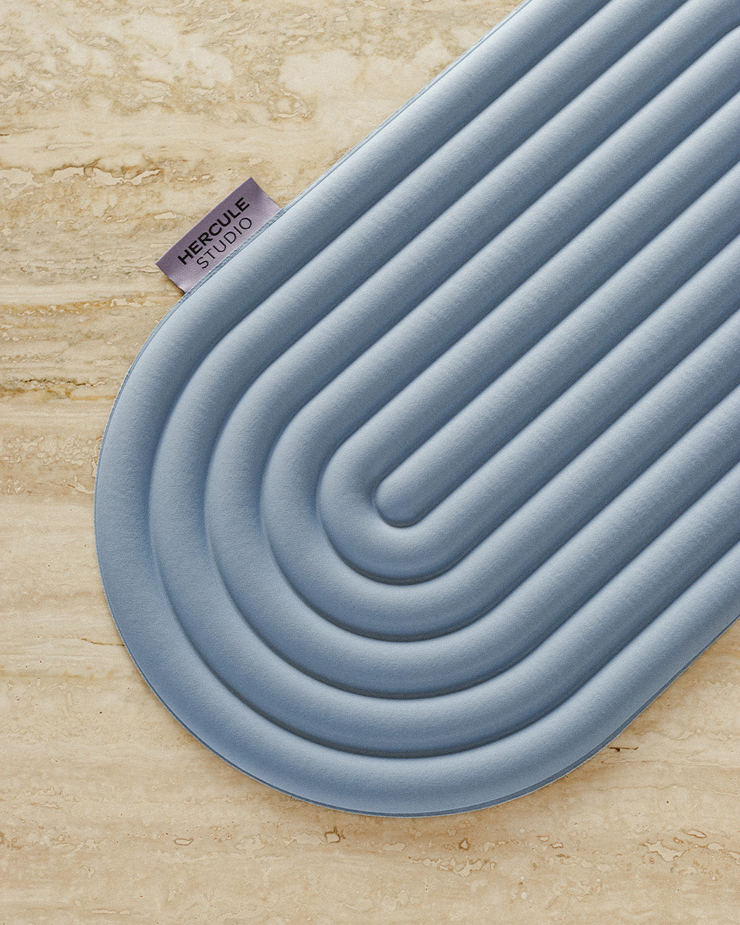 Mini tapis de sol pad de confort de la marque hercule studio modèle galé couleur blue jean packshot lifestyle sur marbre