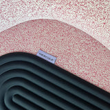Mini tapis de sol pad de confort de la marque hercule studio modèle galé couleur outrenoir déplié sur un fauteuil