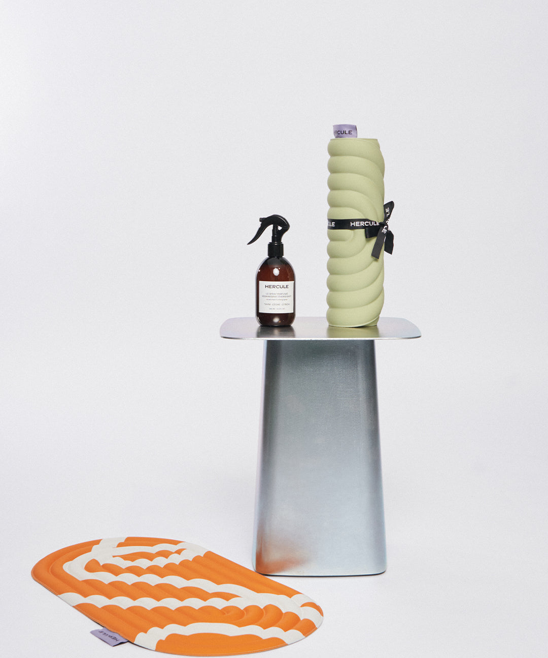 Mini tapis de sol pad de confort de la marque hercule studio modèle galé couleur pistache sur fond blanc avec spray et pad de confort bari orange pop