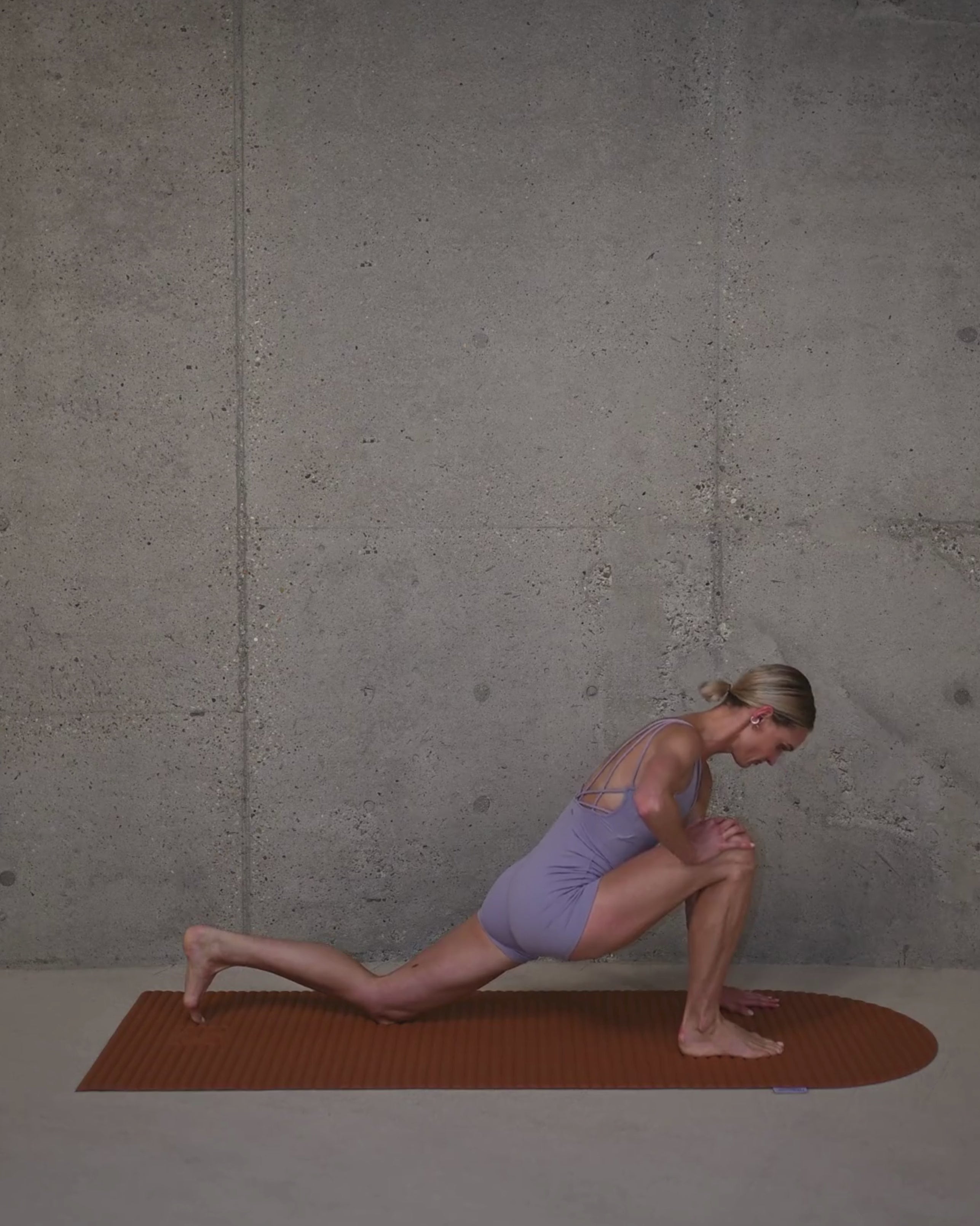 Tapis de sol Hercule Studio Archy terre cuite en situation lifestyle avec mannequin, couleur terracotta chaleureuse pour séance de pilates, design français premium