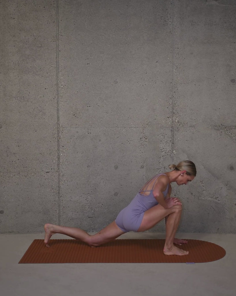 Tapis de sol Hercule Studio Archy terre cuite en situation lifestyle avec mannequin, couleur terracotta chaleureuse pour séance de pilates, design français premium