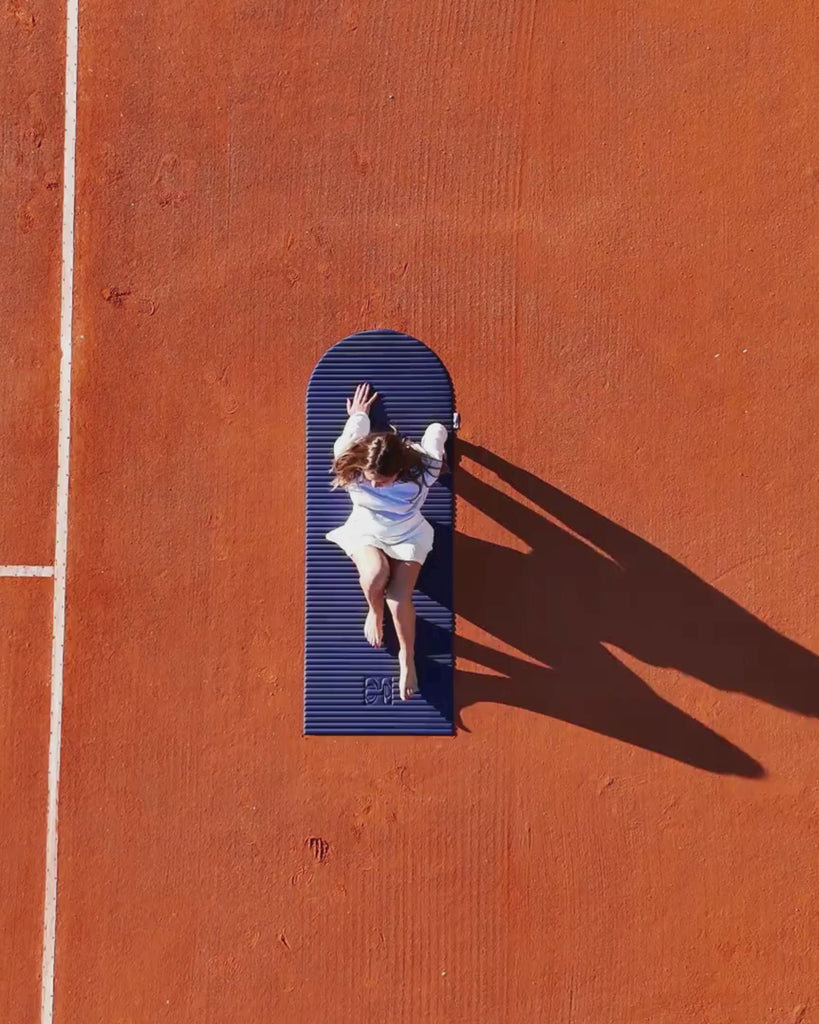 Session sport lifestyle avec tapis de sol Hercule Studio Archy navy, tapis premium bleu nuit pour pilates, étirements et entraînement au sol