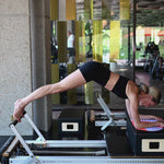 Pilates Reformer session with the Galé Hercule Studio Axel red and purple comfort pad, providing support for sensitive areas and featuring a graphic print, a sustainable travel accessory