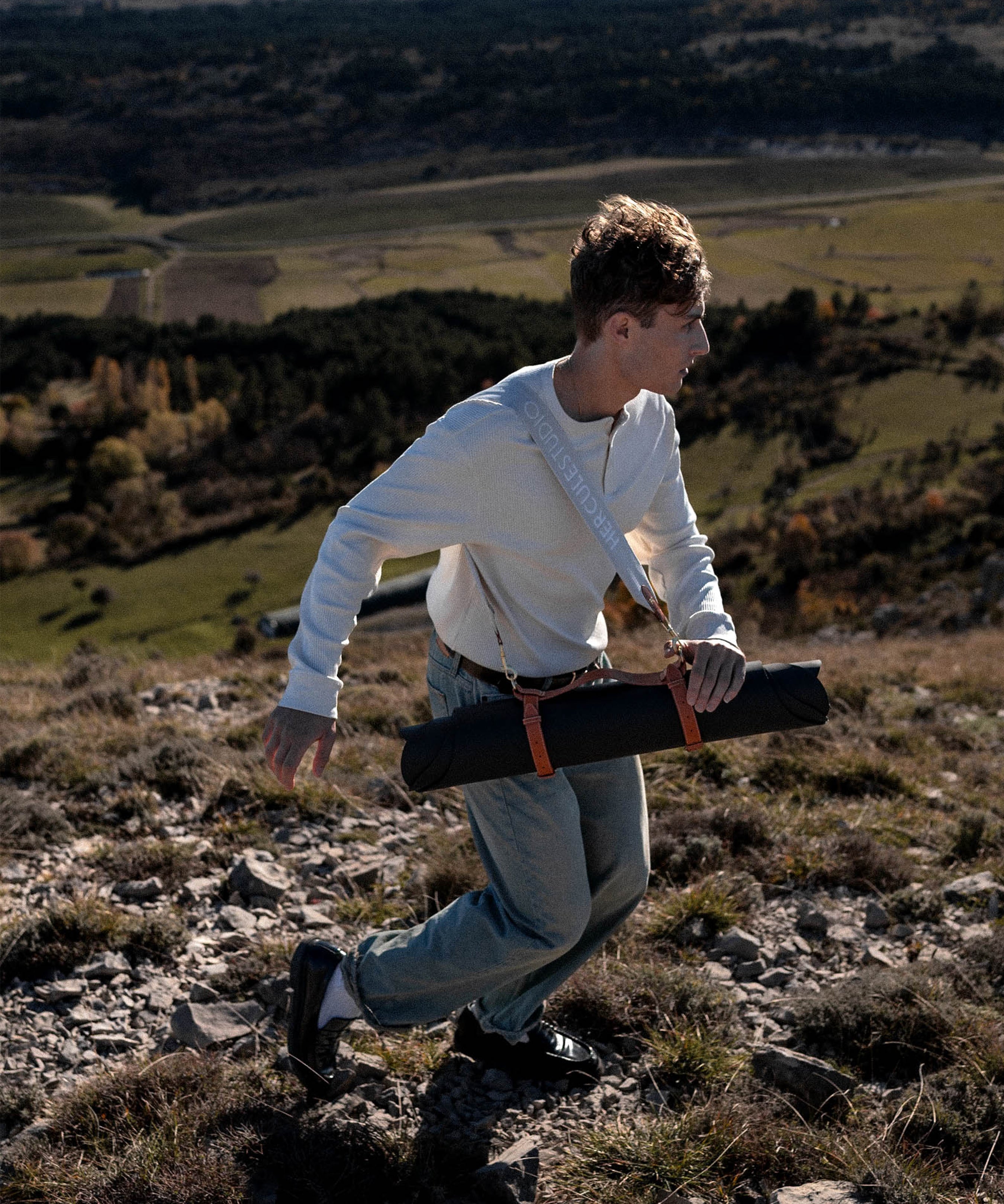 Sangle de transport pour tapis d'exercice modèle soca couleur beige et camel portée en bandoulière avec tapis de yoga mar outrenoir