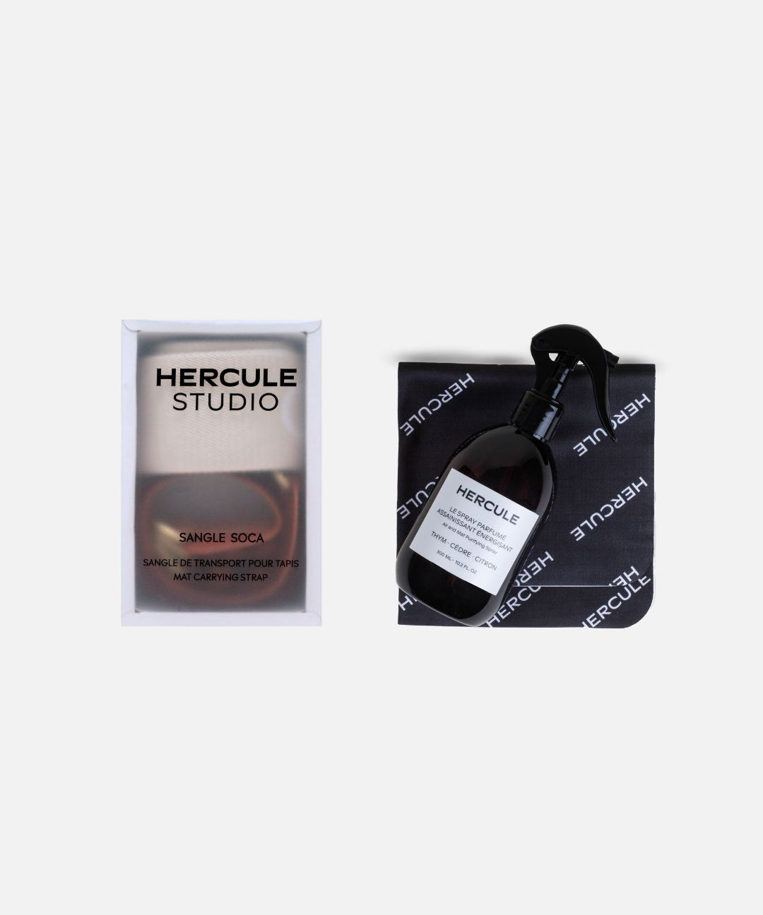 Set accessoires Hercule Studio comprenant spray assainissant pour tapis de sport et sangle de transport élégante, duo pratique pour nettoyer, transporter et entretenir tapis de yoga, Pilates et fitness, accessoires design Made in France, packshot produits