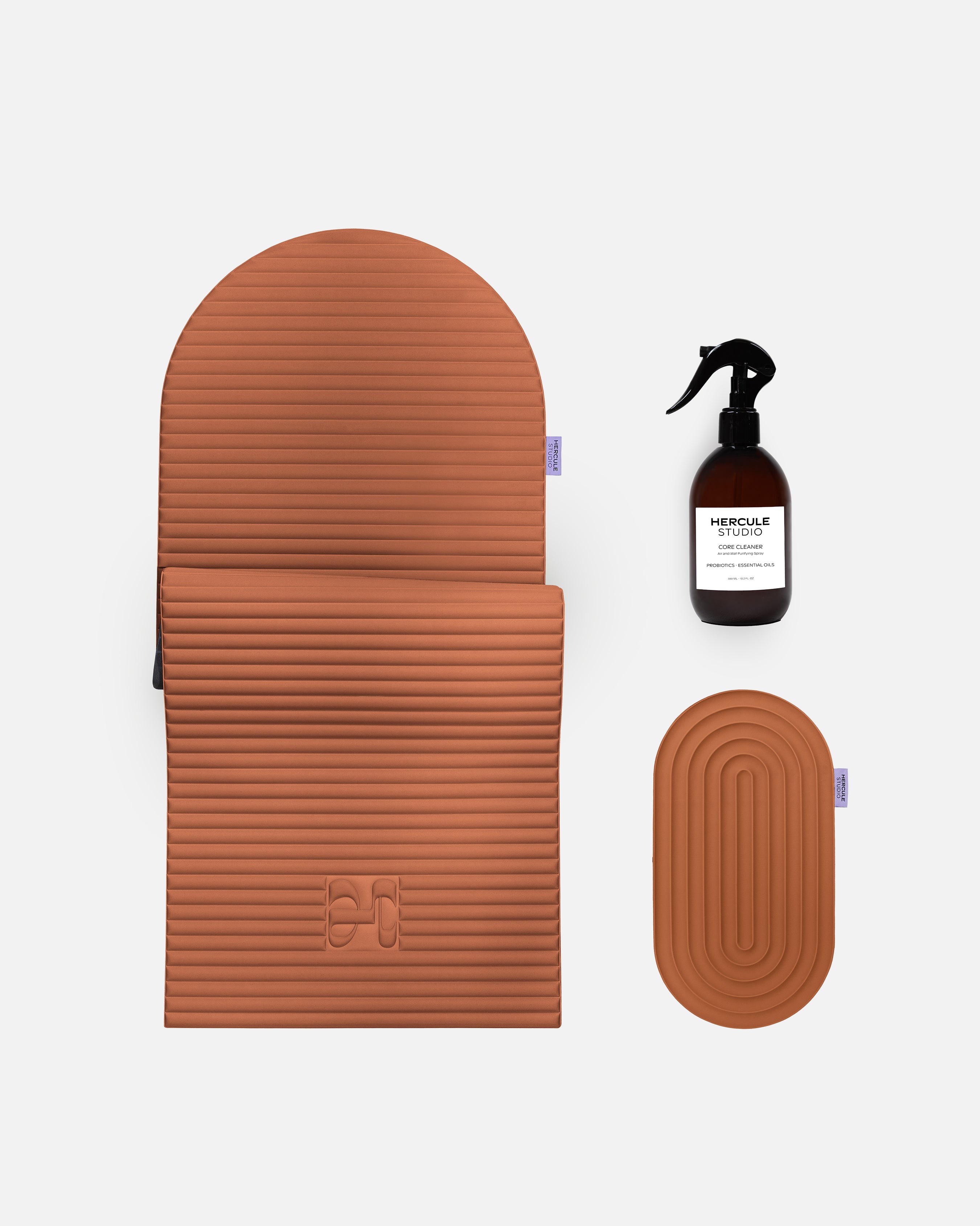 Hercule Studio terracotta essential bundle including the Archy arch-shaped sport mat, the Galé 3-in-1 comfort pad for knees and elbows and the sanitizing spray, durable Made in France Pilates and fitness bundle, packshot of grouped products