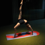 Tapis de sol pour le fitness le yoga et le pilates de la marque hercule studio modèle archy couleur imprimé axel rouge orangé photo avec un mannequin qui fait du sport sur le tapis