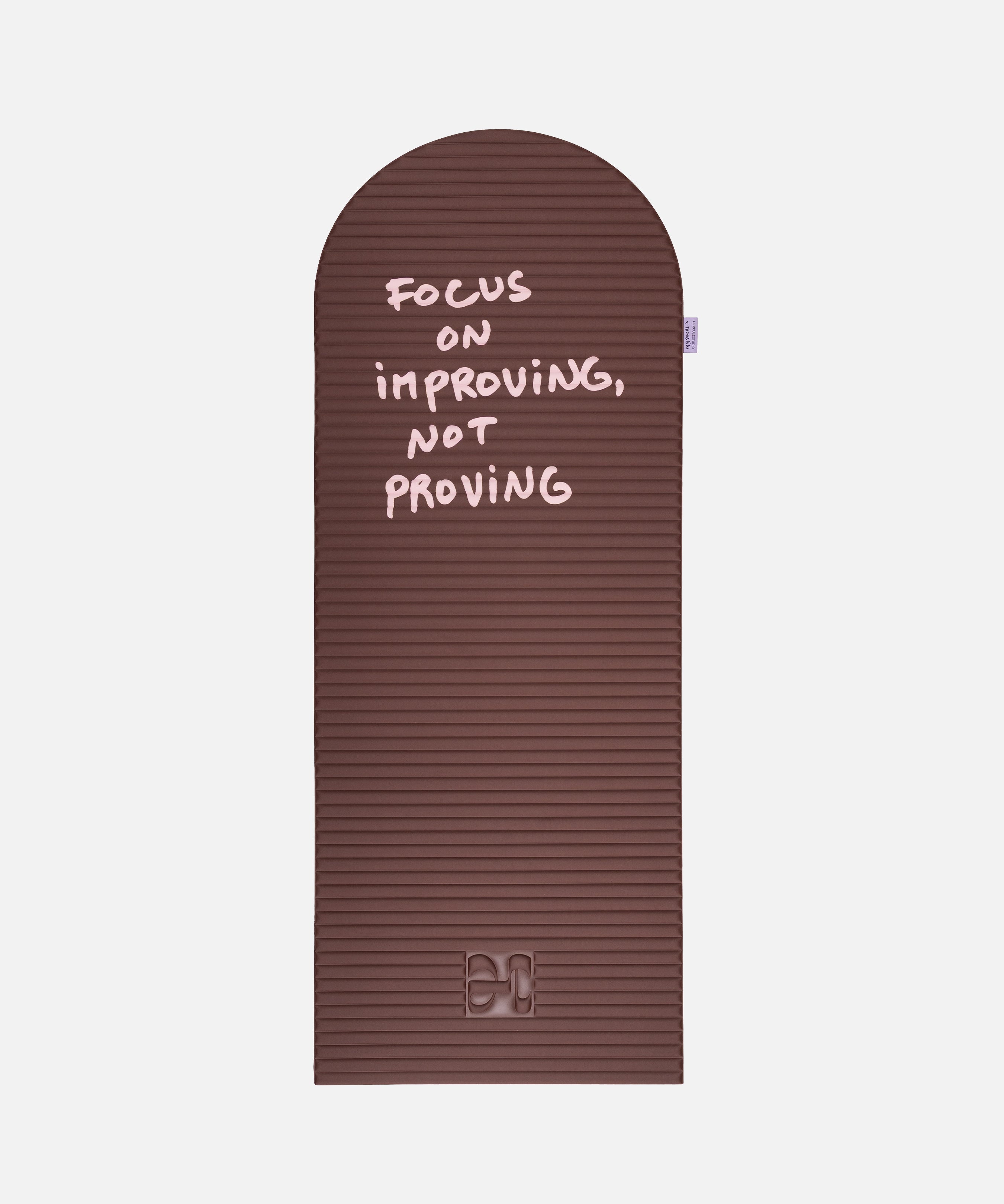 Hercule Studio x Thomas Lélu Limited Edition Exercise Mat, brown designer floor mat featuring a pink quote reading “focus on improving not proving,” an artistic collaboration for fitness, Pilates, and stretching, unfolded view
