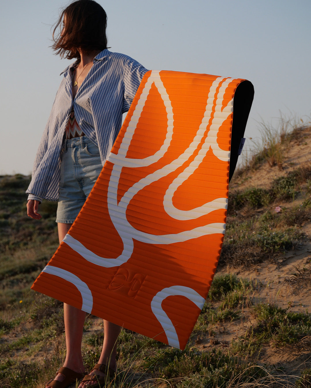 Tapis de sol pour le fitness le yoga et le pilates de la marque hercule studio modèle archy couleur imprimé bari orange pop photo avec un mannequin qui tient le tapis