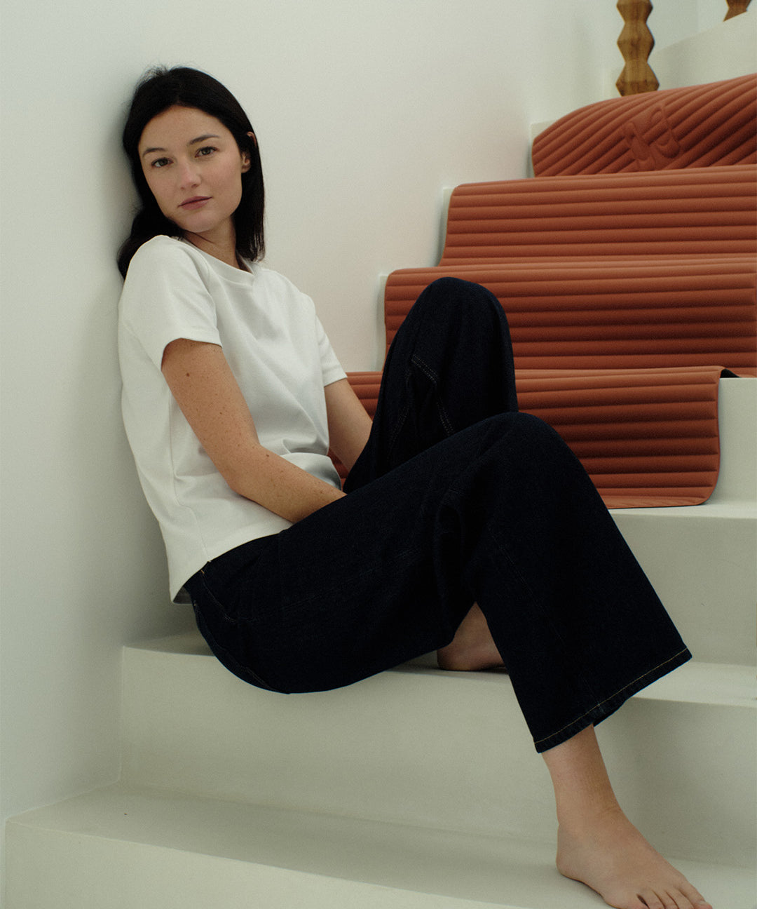 Tapis de sol pour le fitness le yoga et le pilates de la marque hercule studio modèle archy couleur terre cuite photo du tapis dans les escaliers avec mannequin