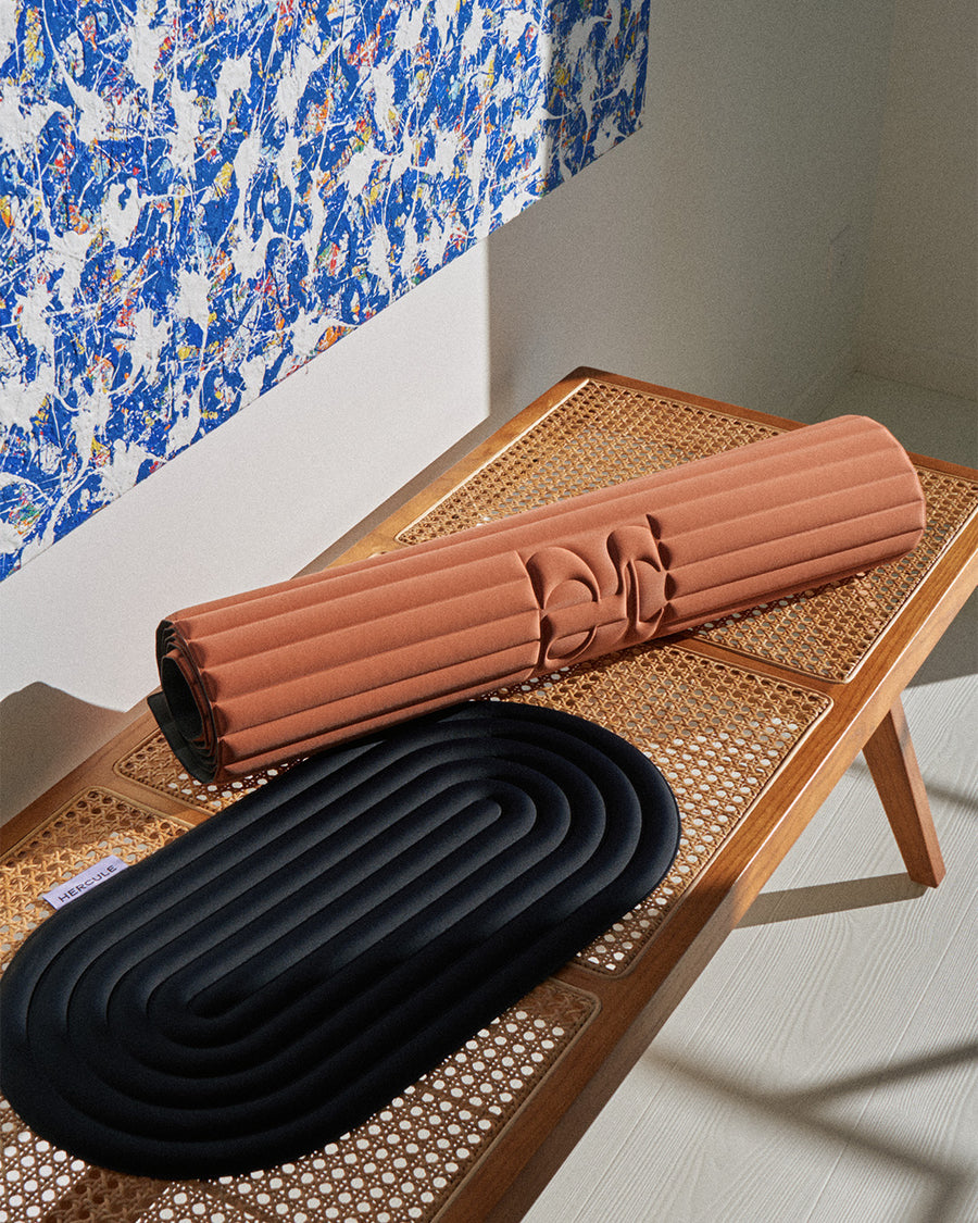 Tapis de sol pour le fitness le yoga et le pilates de la marque hercule studio modèle archy couleur terre cuite photo du tapis roulé à coté du pad de confort noir