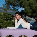 Mannequin allongée sur le rebord d'un balcon avec le tapis de yoga Mar couleur lavande de la marque Hercule Studio