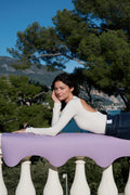 Mannequin allongée sur le rebord d'un balcon avec le tapis de yoga Mar couleur lavande de la marque Hercule Studio