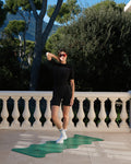 Hercule Studio yoga mat, “Mar” model in golf green, photo showing a model standing on the mat