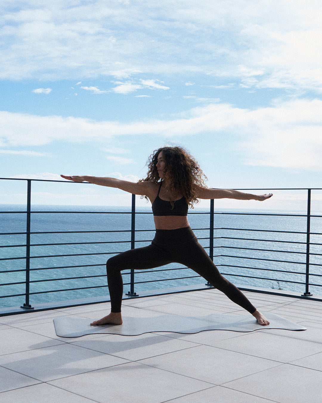 Tapis de sol pour le yoga de la marque hercule studio modèle mar couleur greige lifestyle mannequin posture du guerrier