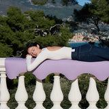 Tapis de sol pour le yoga de la marque hercule studio modèle mar couleur lavande lifestyle avec mannequin allongé sur le rebord du balcon